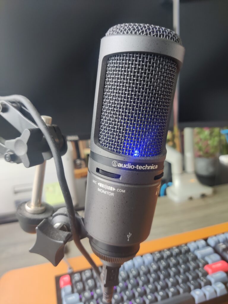 The microphone within my home office setup that I use on a daily basis, the Audio Technica AT2020+.